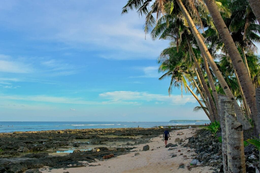 man walking along the beach in siargao as a long term resident